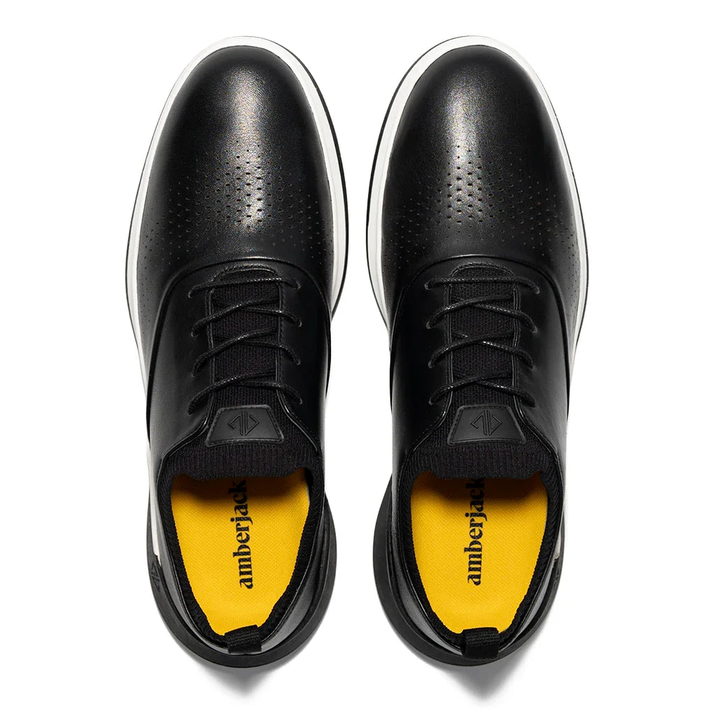 Black shoes with yellow soles on a white background