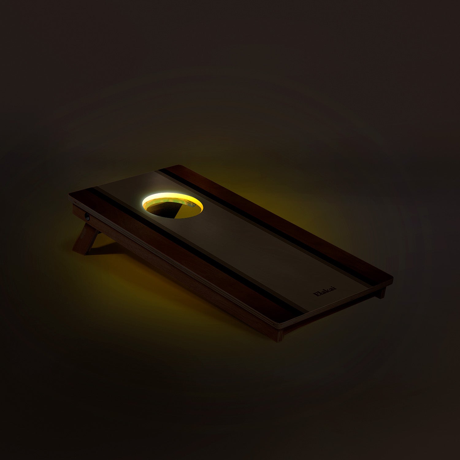Cornhole board with a glowing disc on a dark background
