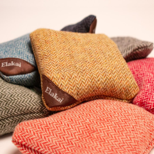 Stack of woven fabric samples with 'Elakai' branding on a neutral background