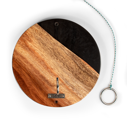 Wooden circular cutting board with a black center on a white background