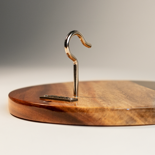 Wooden cutting board with a metal hook on a neutral background