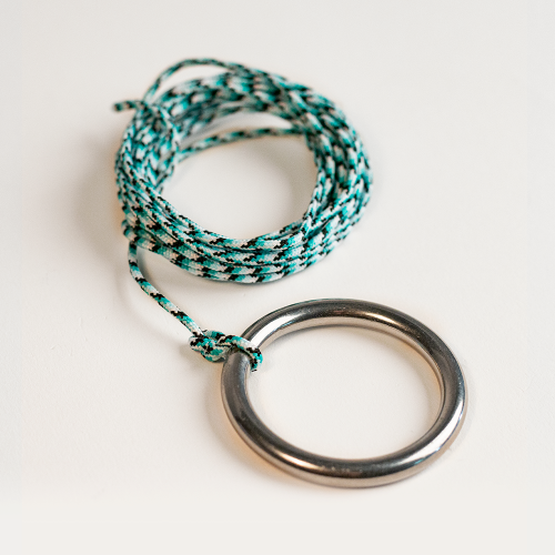 Necklace with braided cord and metal ring on a light background