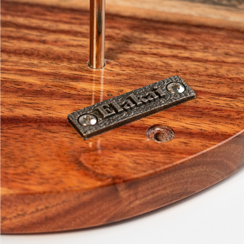 Close-up of a wooden product with a metal label on a white background