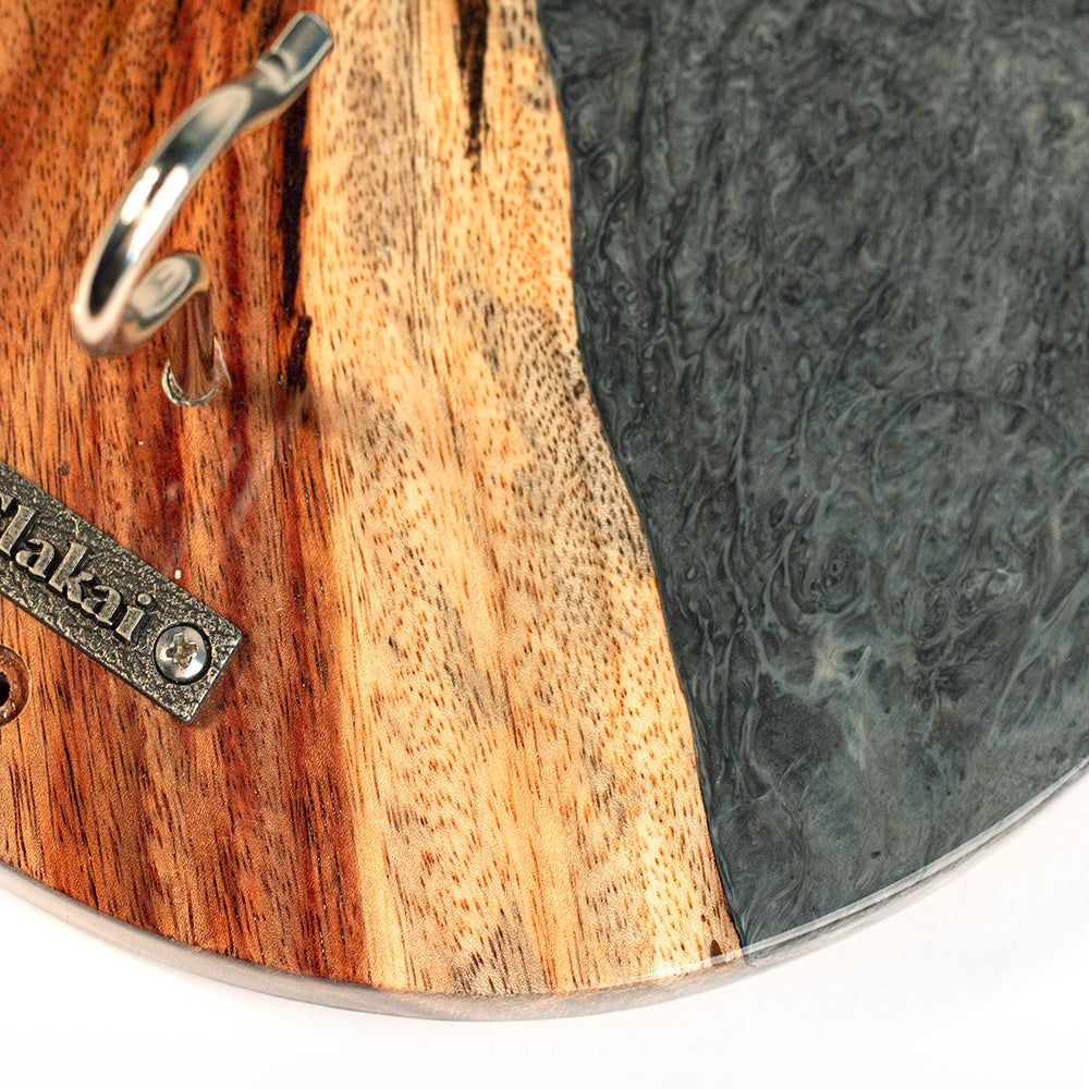 Close-up of a wooden cutting board with a metal handle and 'Hakai' branding.