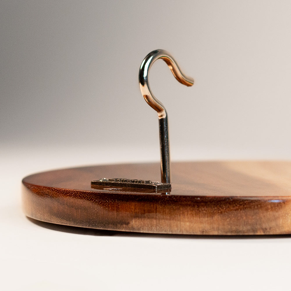 Metal hook on a wooden surface with a neutral background