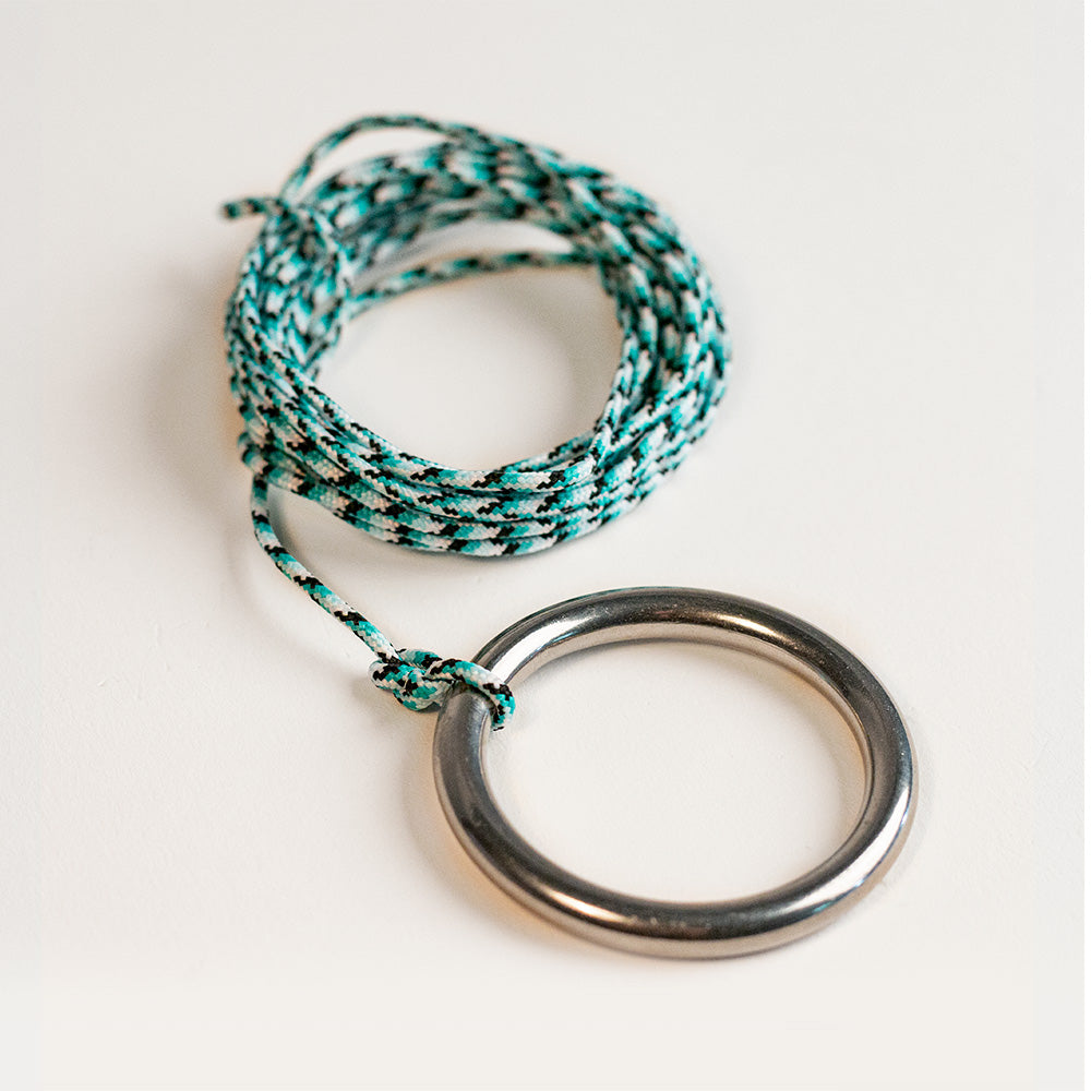 Necklace with braided cord and round metal pendant on a white background
