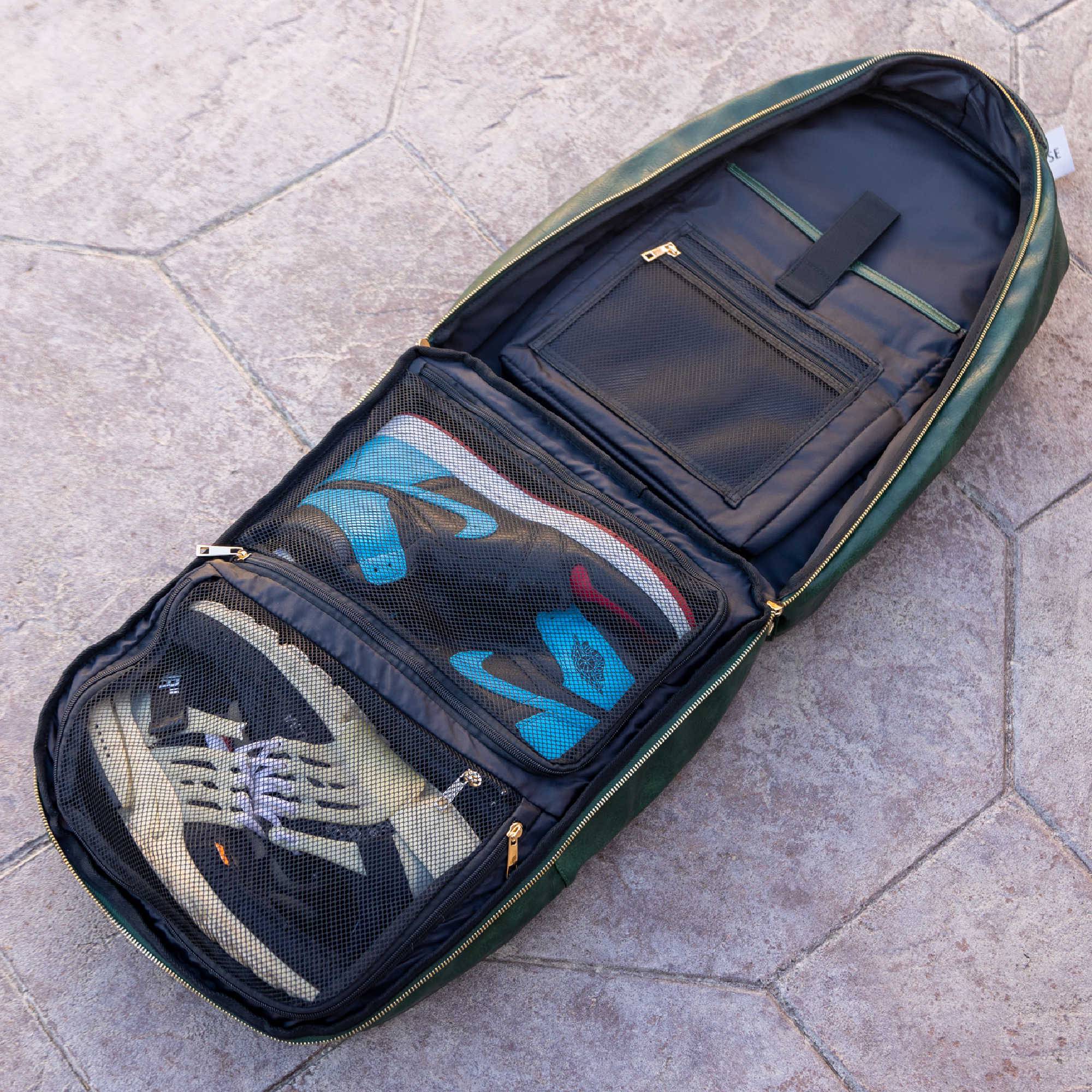 Green travel bag with compartments on a stone pavement
