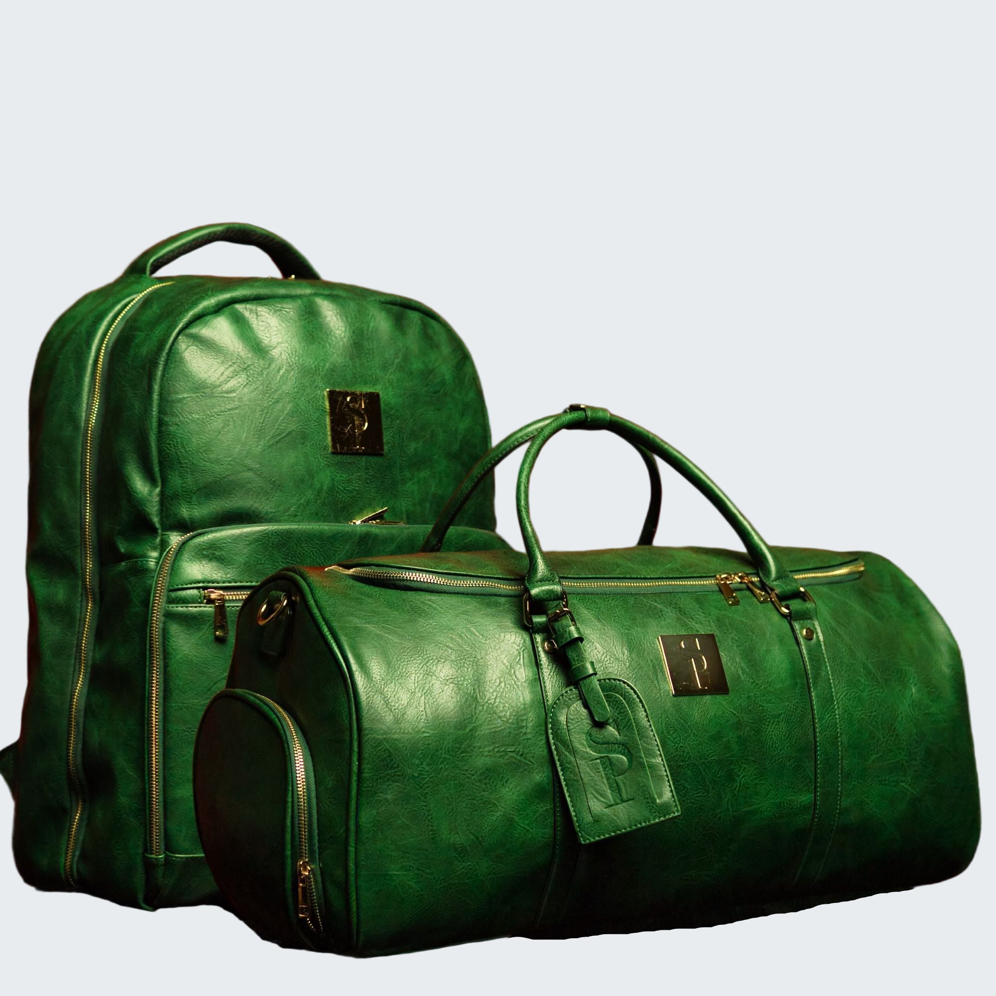 Green leather backpack and duffel bag against a red background