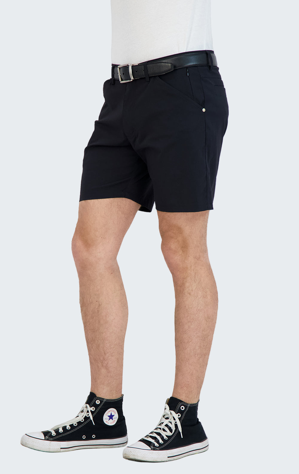 Person wearing black shorts and black high-top sneakers on a white background