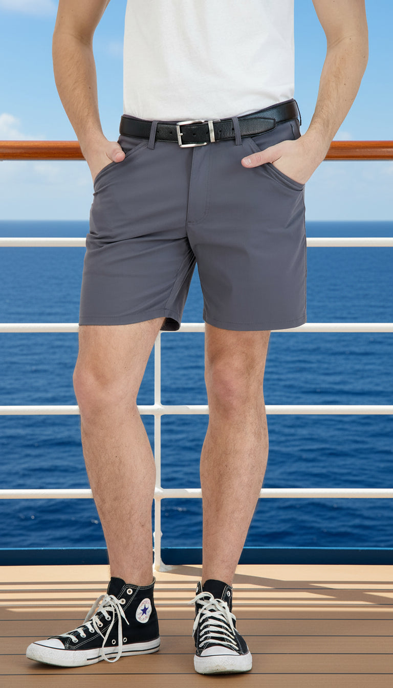 Person wearing gray shorts, a white shirt, and black high-top sneakers on a white background