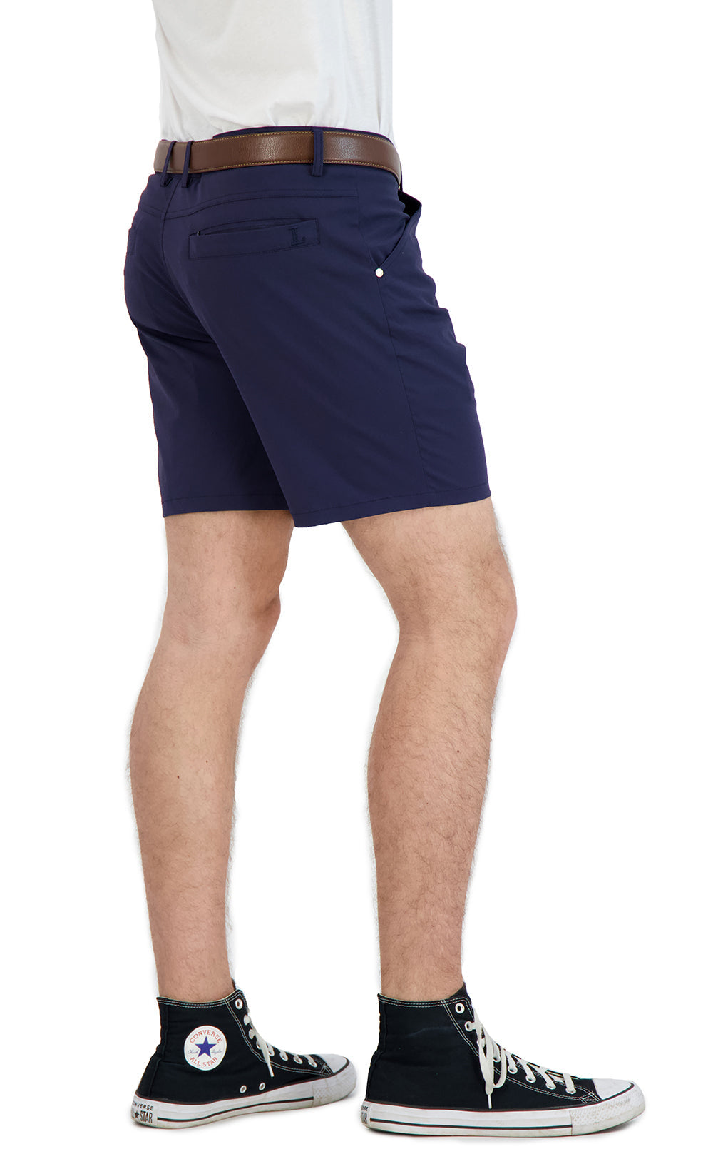 Person wearing navy shorts with a brown belt and black sneakers on a white background