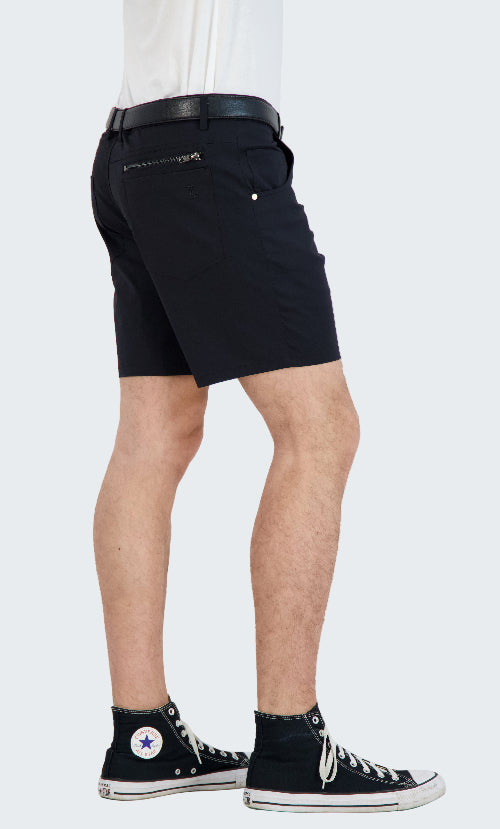 Person wearing black shorts with zippers on a white background