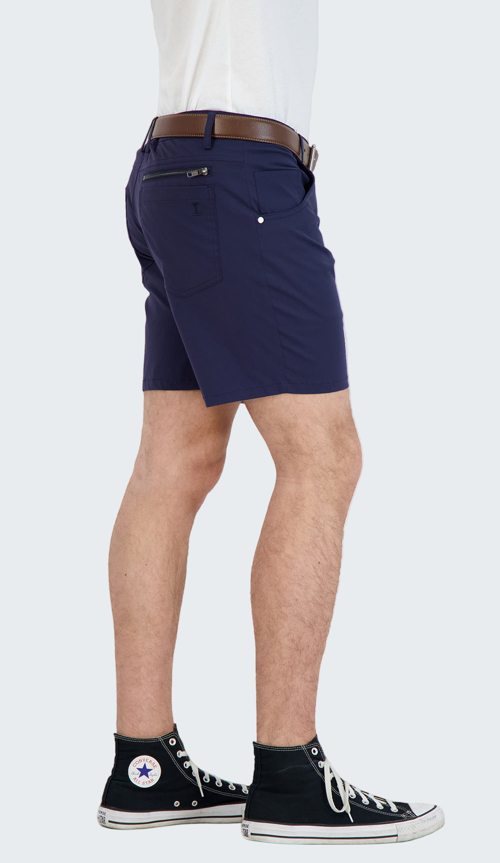 Person wearing navy shorts with a white background