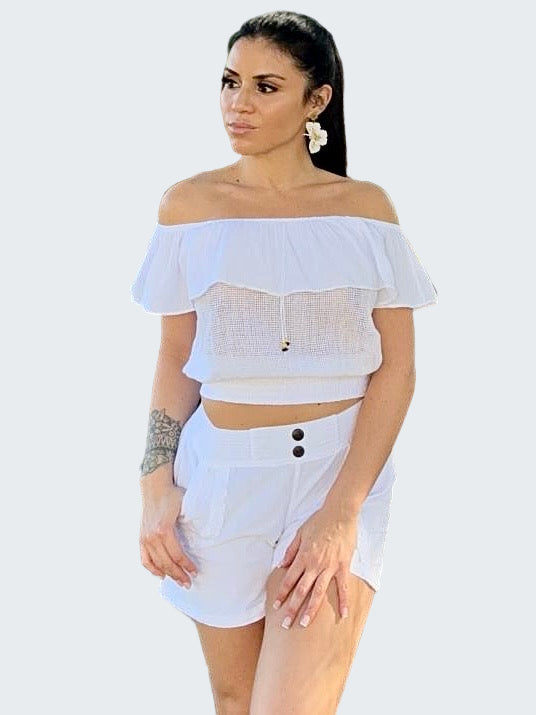 Woman wearing a white off-shoulder top and shorts in an outdoor setting