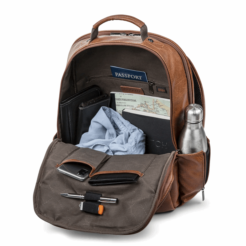 Open brown backpack with various items including a passport, phone, and water bottle.