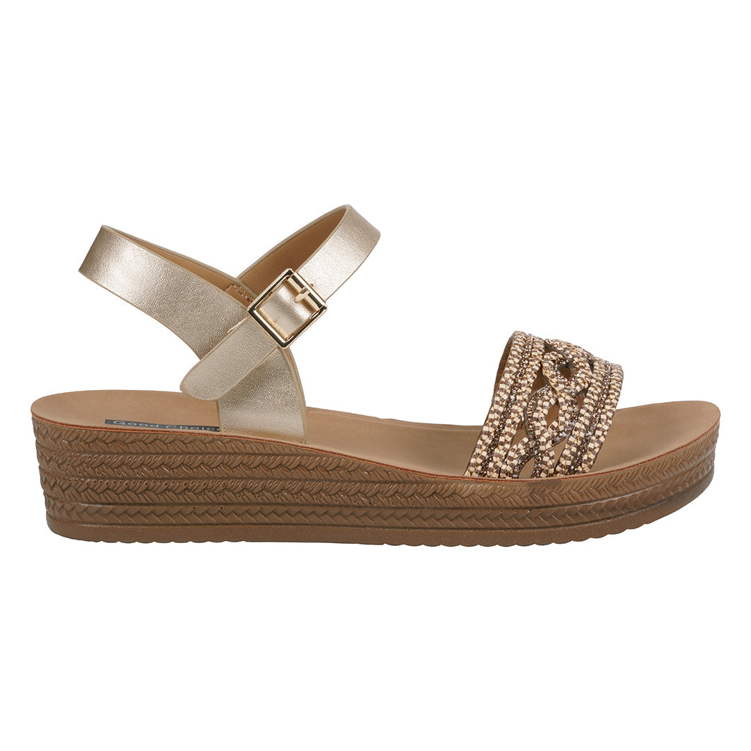 Gold sandal with a woven sole on a white background