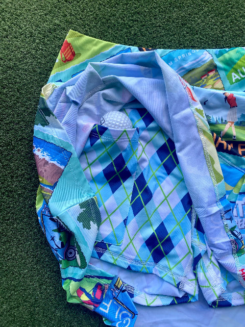 Colorful quilt with golf-themed patterns on a green surface