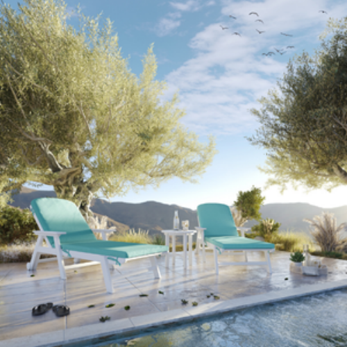Two turquoise lounge chairs by a pool with trees and mountains in the background