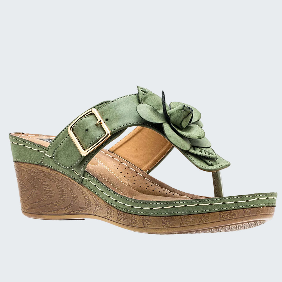 Green wedge sandal with floral design on a white background