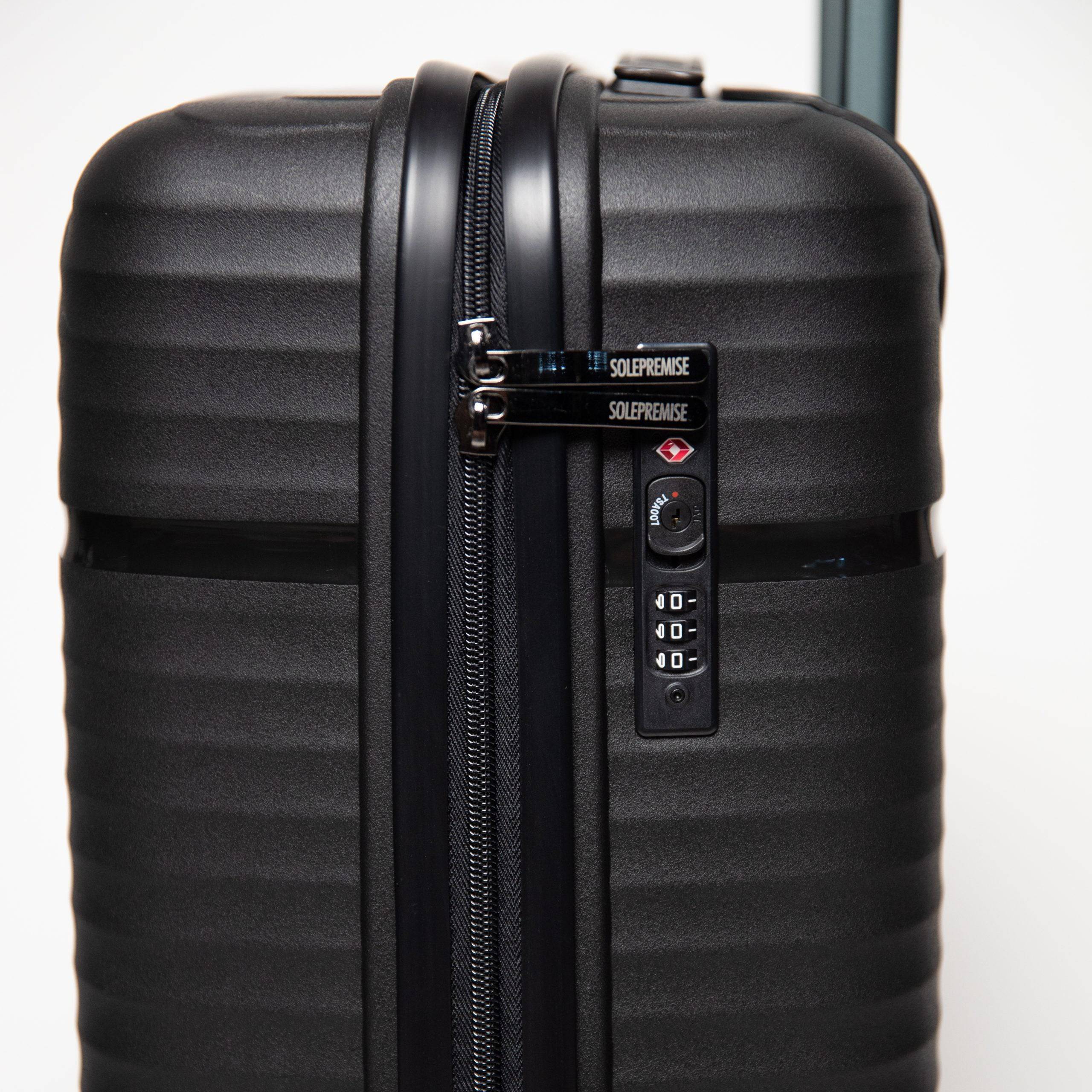 Black suitcase with a visible brand logo on a white background