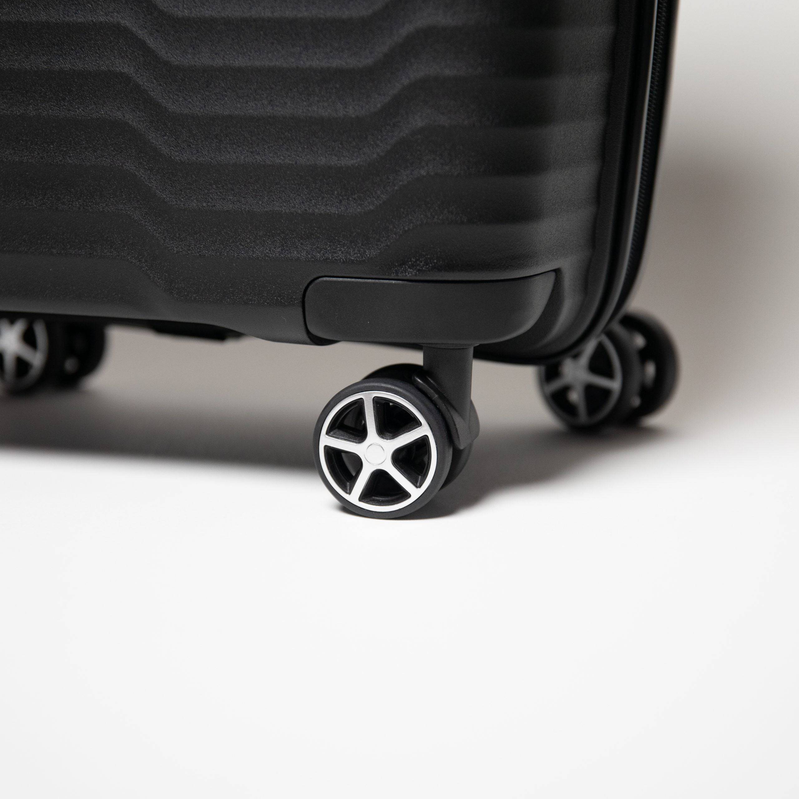 Close-up of a black suitcase with wheels on a light background