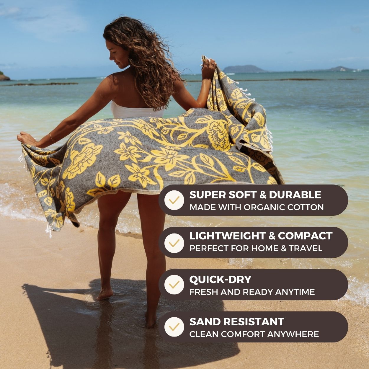 Woman on a beach holding a floral towel with product features listed below.