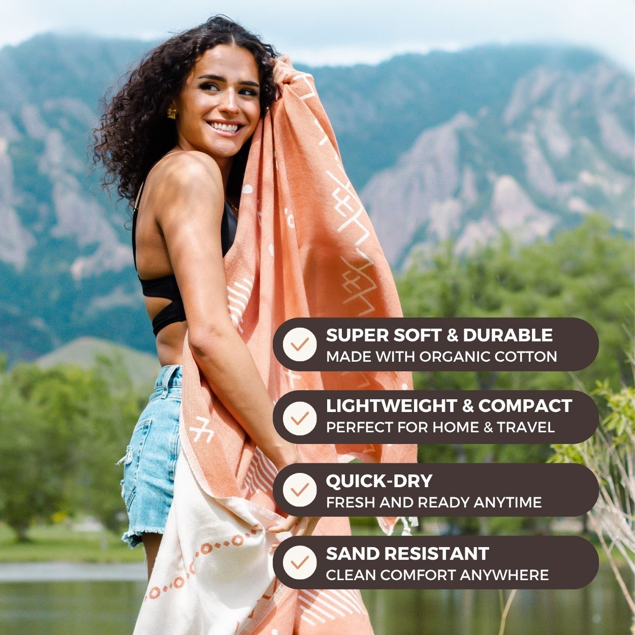 Woman holding a towel outdoors with mountain and nature background