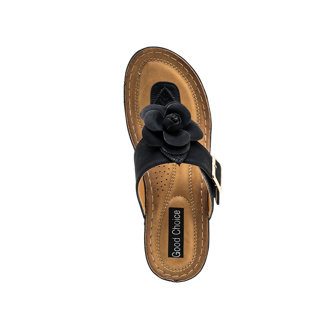Brown sandal with black flower detail on a white background