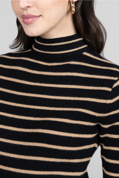 Close-up of a person wearing a black and beige striped turtleneck sweater.