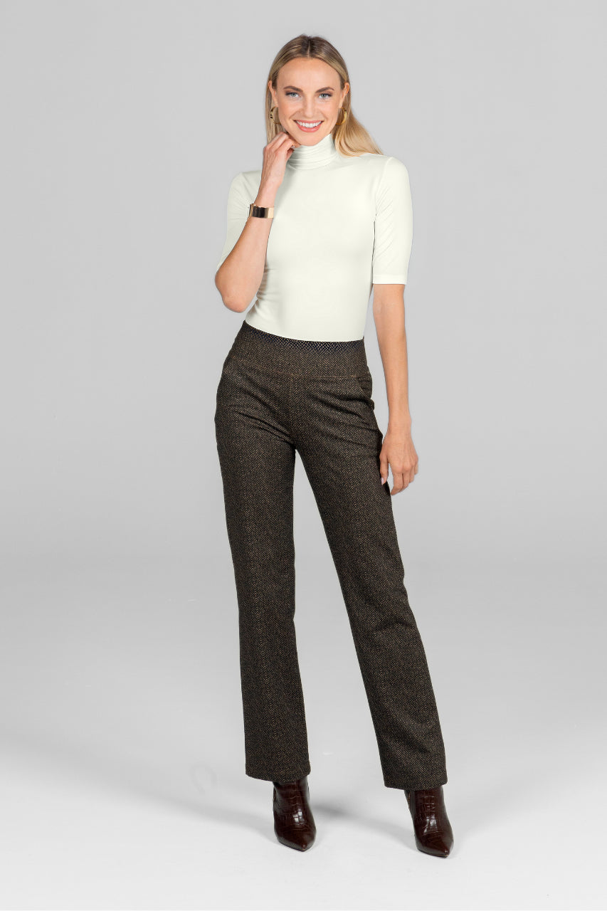 Woman wearing a white top and brown checkered pants on a light gray background