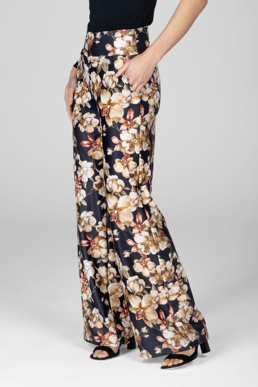 Floral patterned pants worn by a person on a plain background
