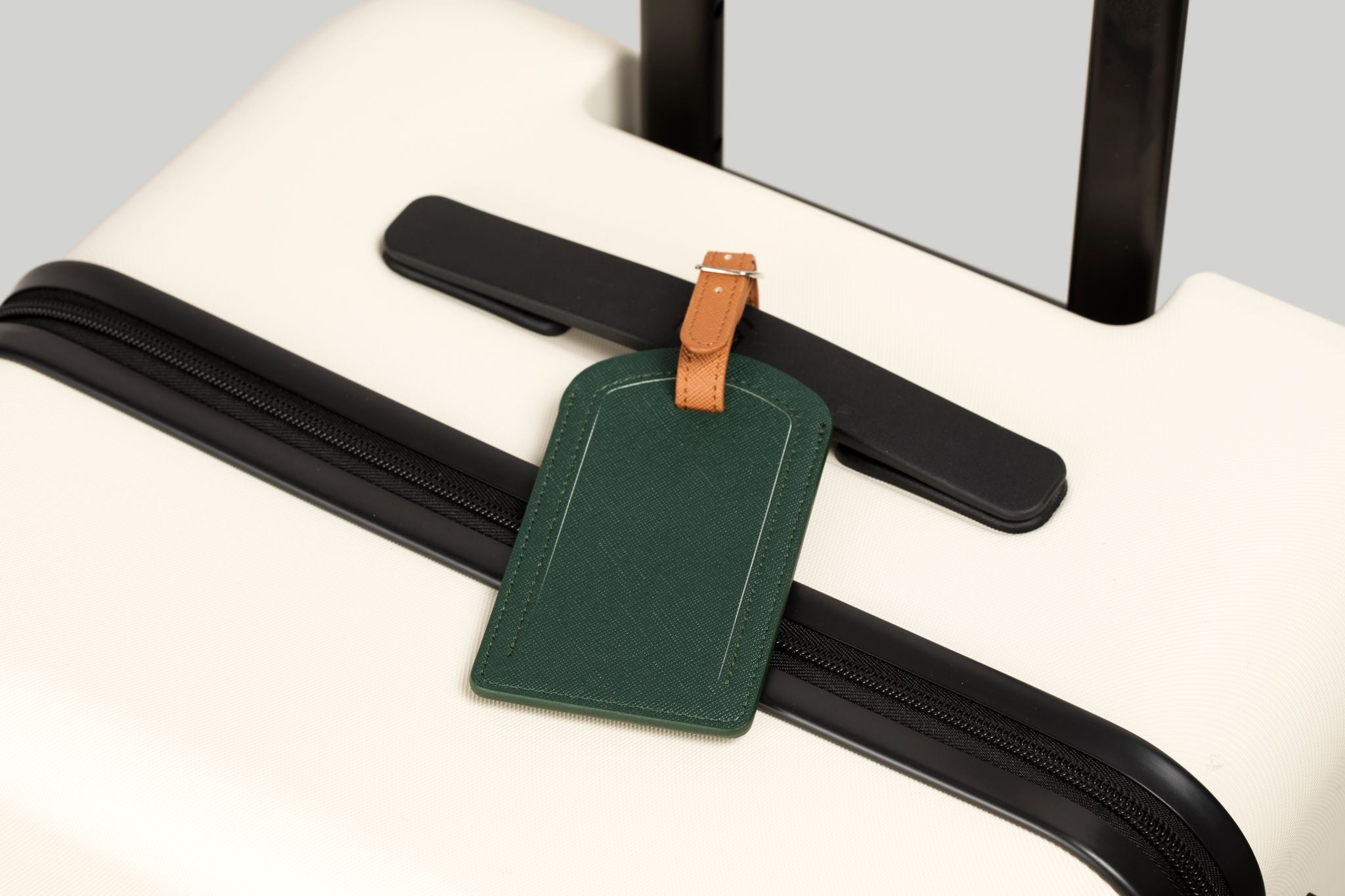 Green luggage tag attached to a suitcase handle