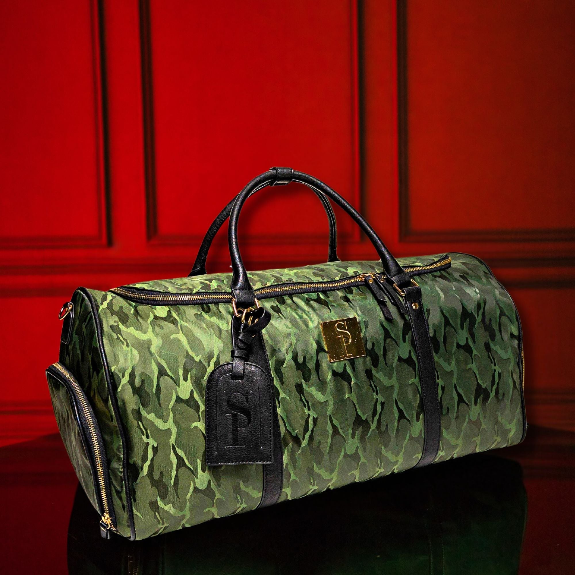 Green camouflage duffel bag with black accents against a red background