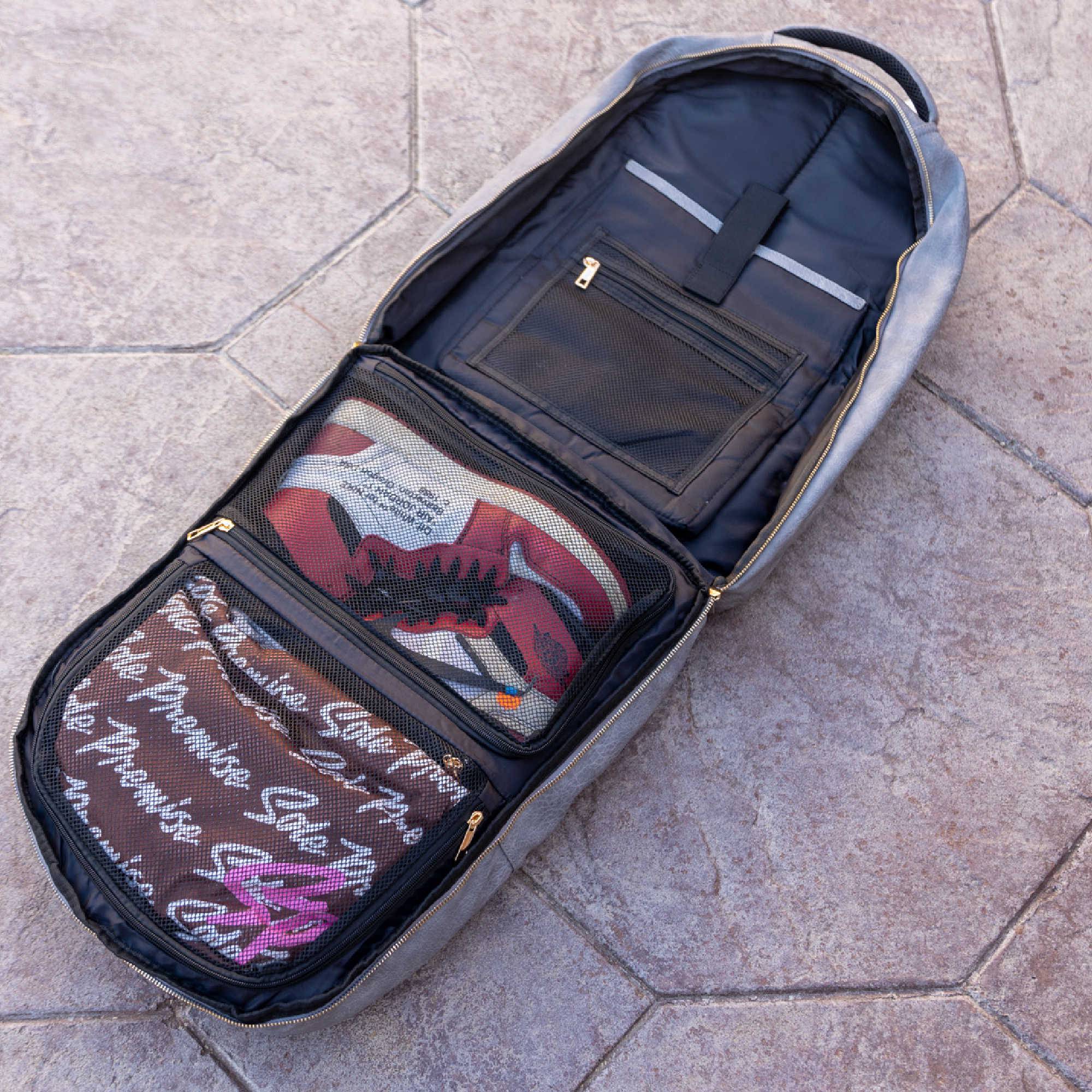 Open travel bag on a tiled floor with items inside