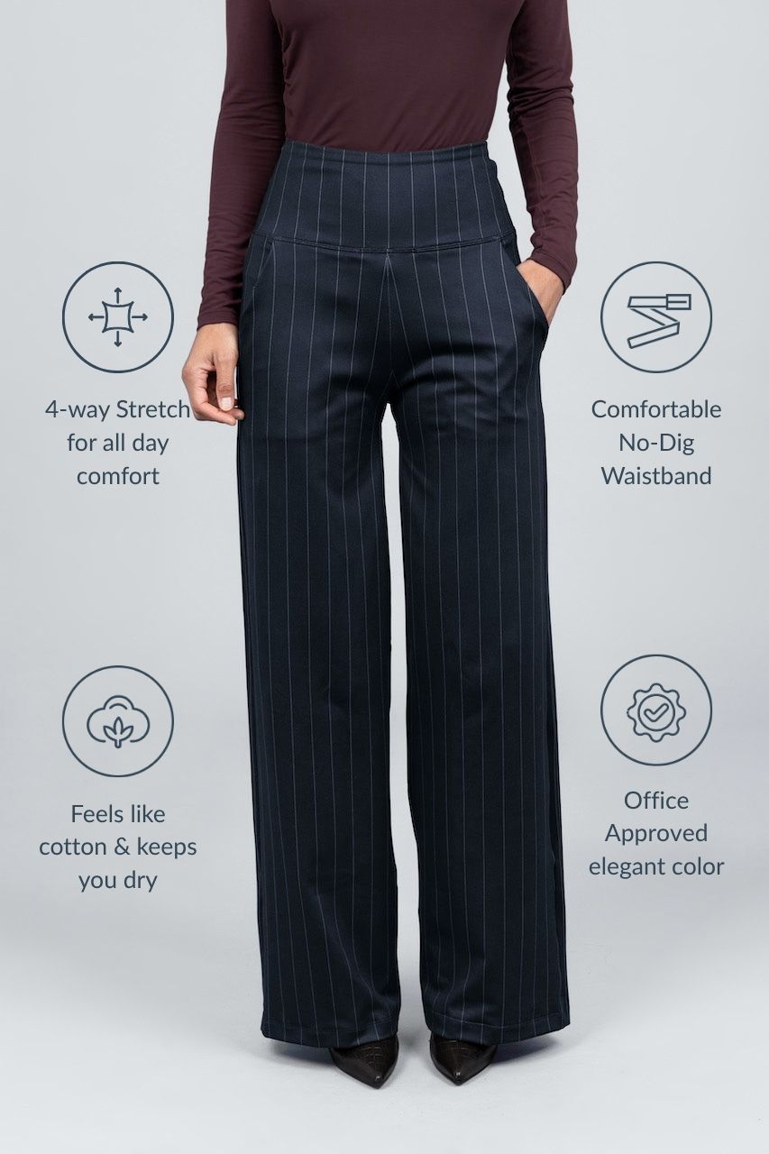 Person wearing black pinstripe pants with product features on a light gray background