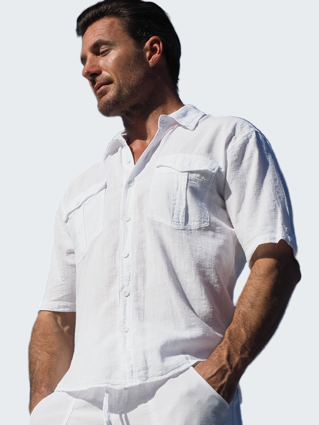 Man wearing a white shirt against a clear blue sky