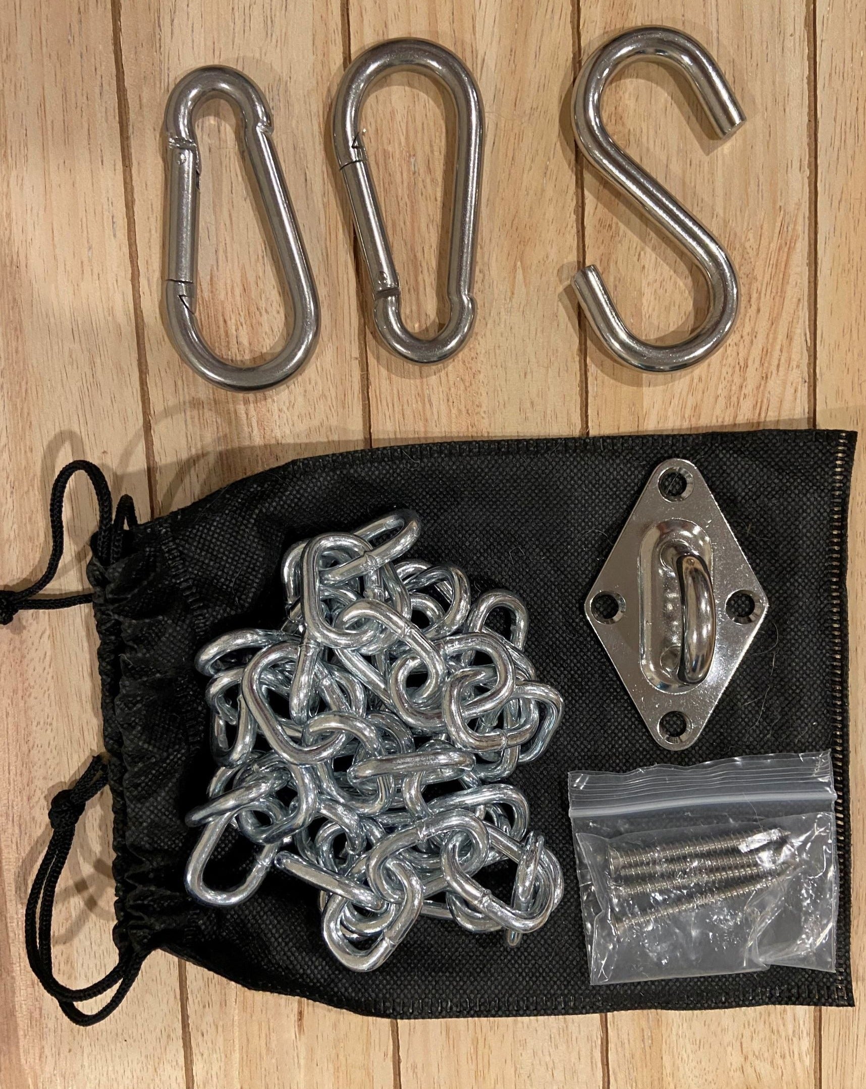 Set of metal hooks and chains on a wooden surface with a black drawstring bag.