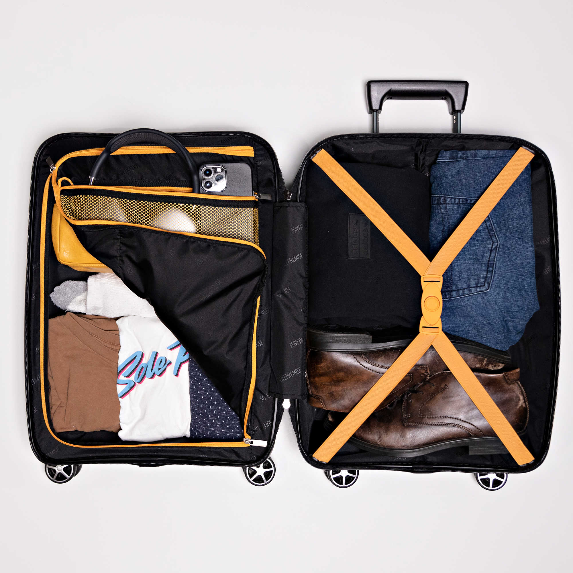 Open suitcase with clothes and items on a white background