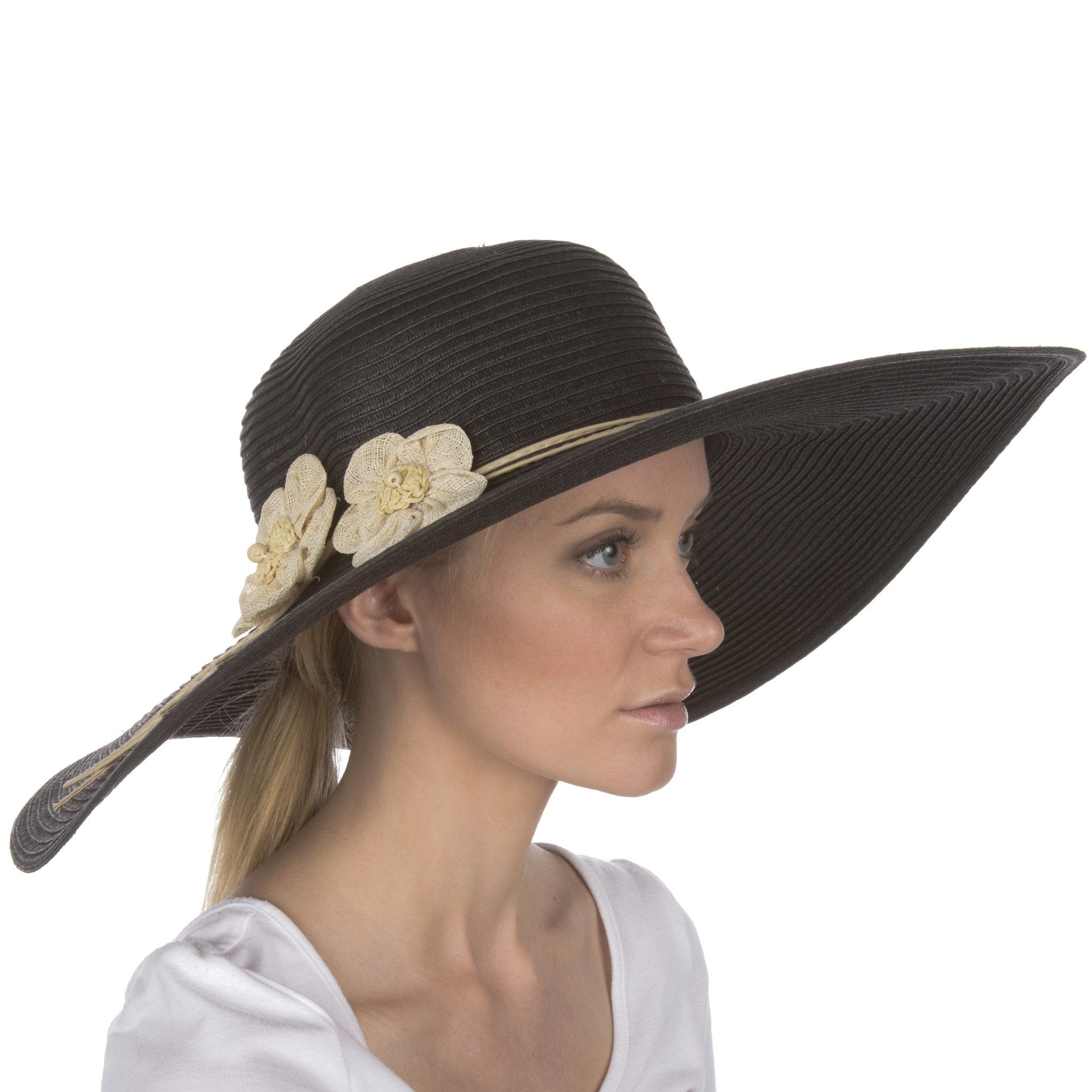 Woman wearing a black sun hat with floral embellishments on a white background