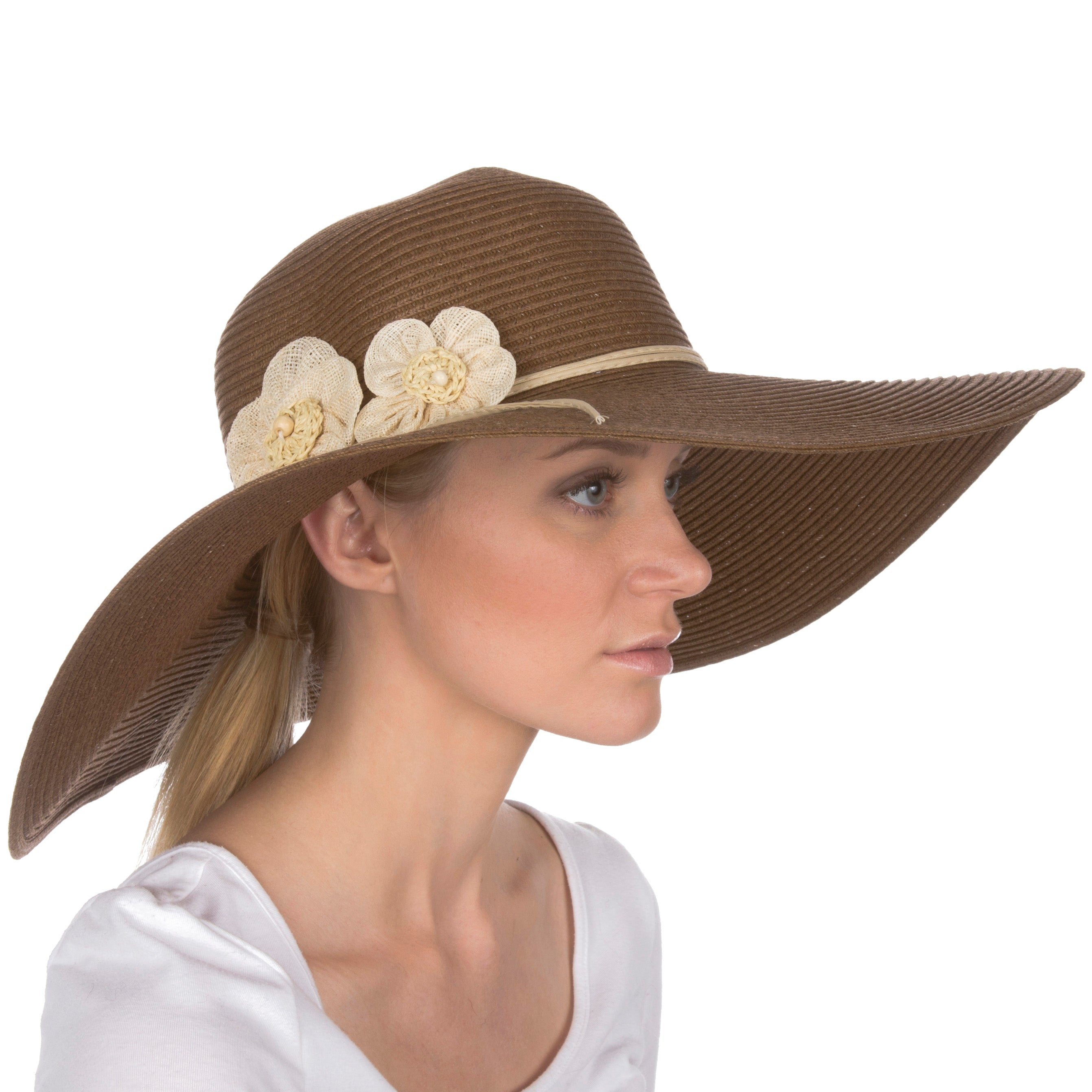 Woman wearing a brown sun hat with floral embellishments on a white background