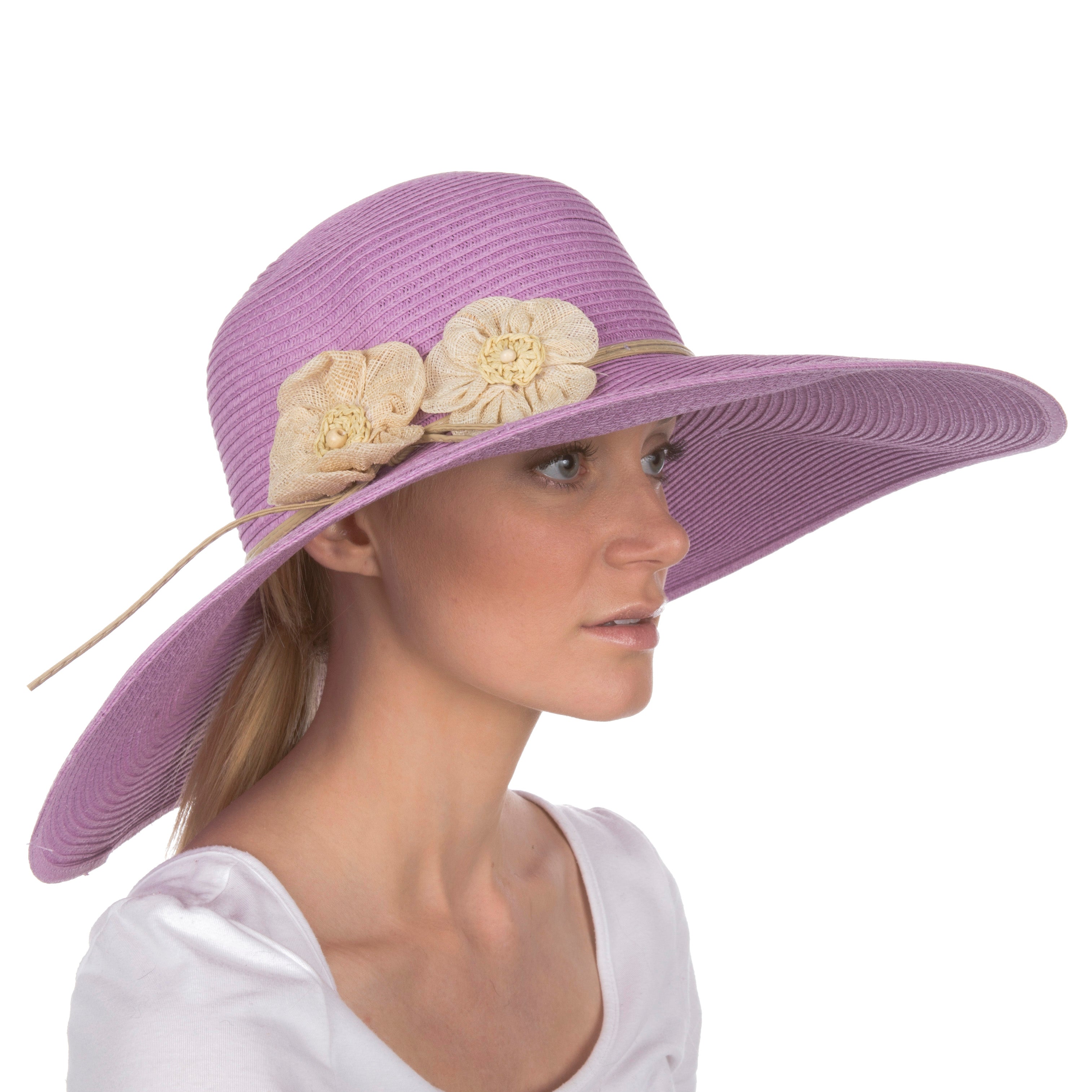 Purple sun hat with floral embellishments worn by a model on a white background