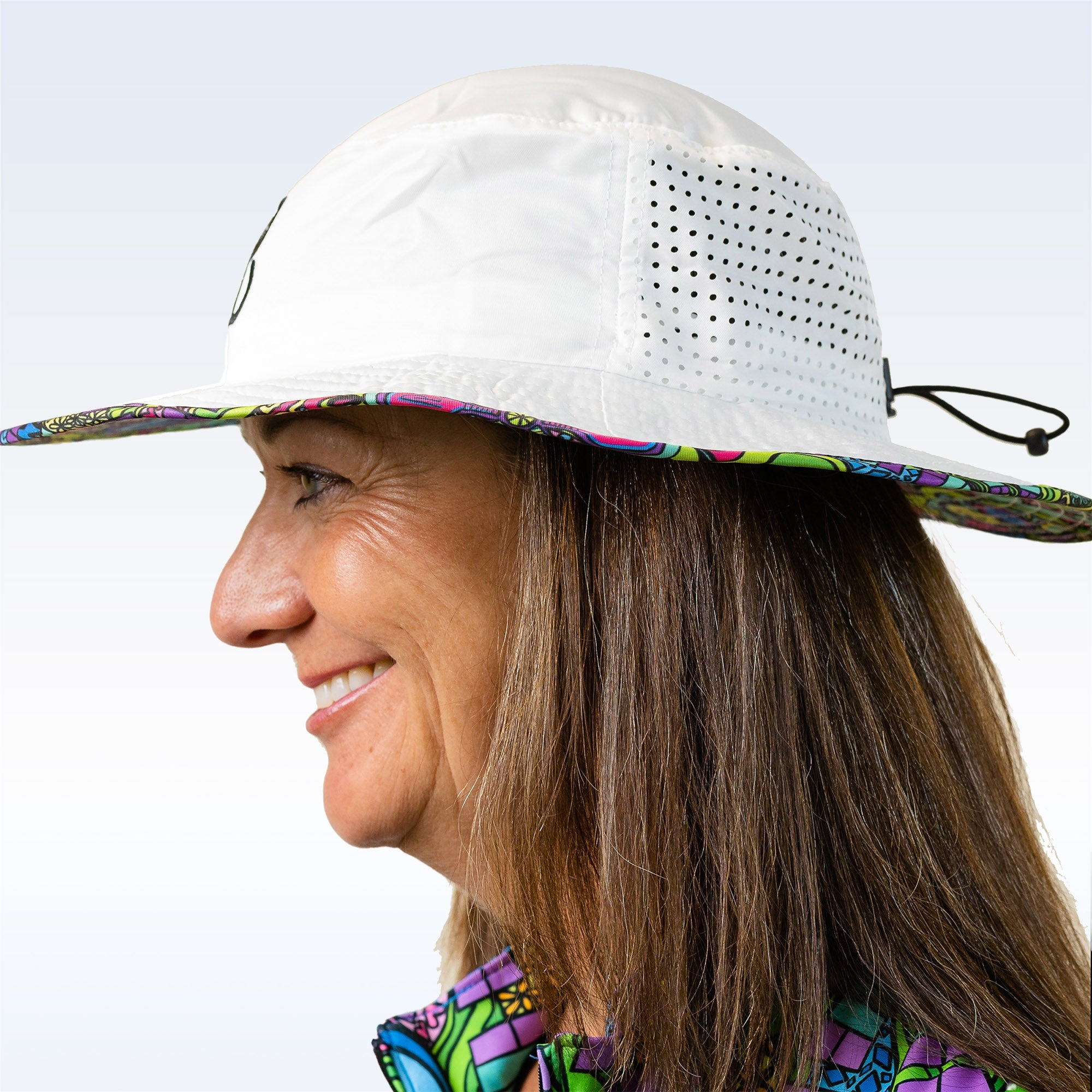 Person wearing a white sun hat with colorful brim against a light blue background