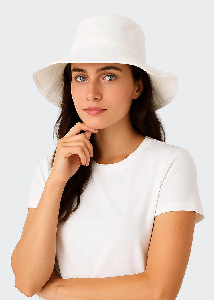 Woman wearing a white hat and white shirt against a light background