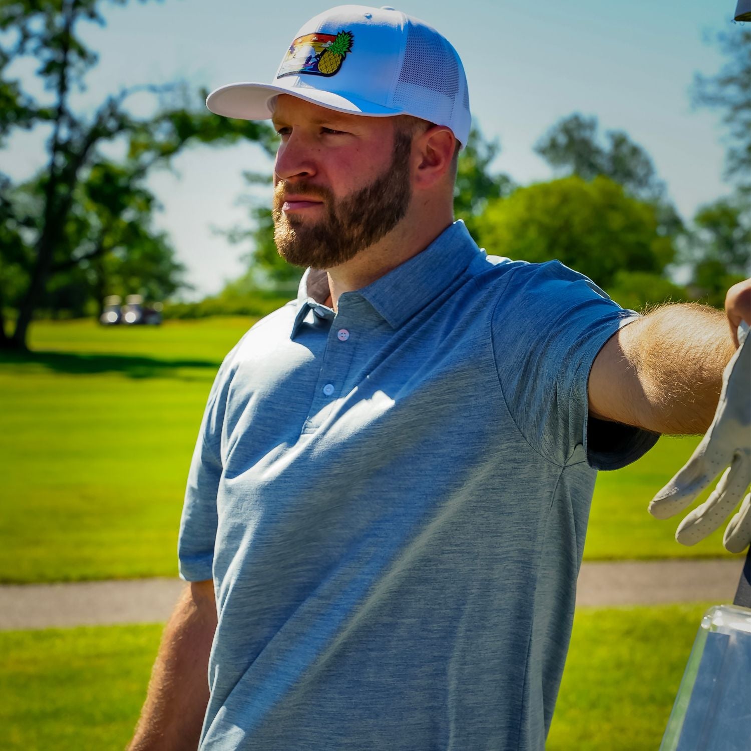 Man in a blue shirt and cap on a golf course
