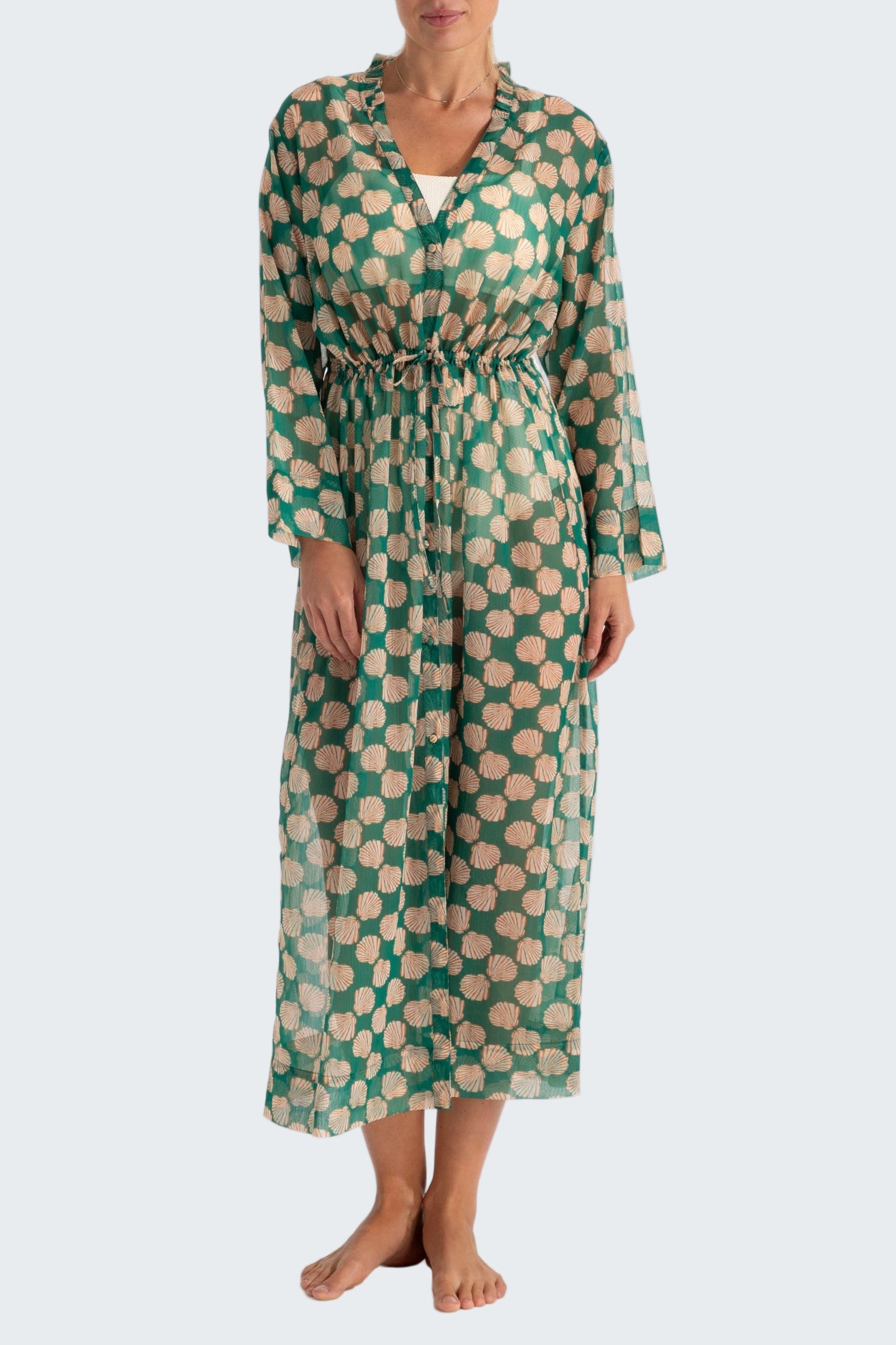 Woman wearing a green and beige patterned dress on a white background