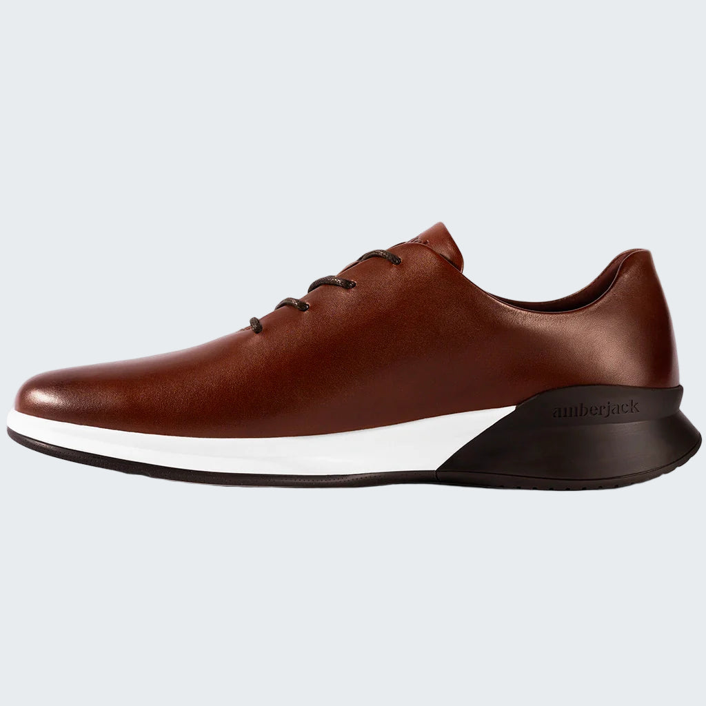 Brown leather shoe with white sole on a white background