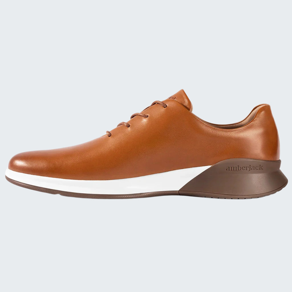 Brown leather shoe with white sole on a white background
