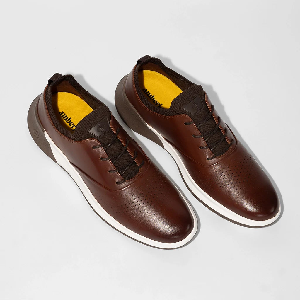 Brown shoes with white soles on a light gray background