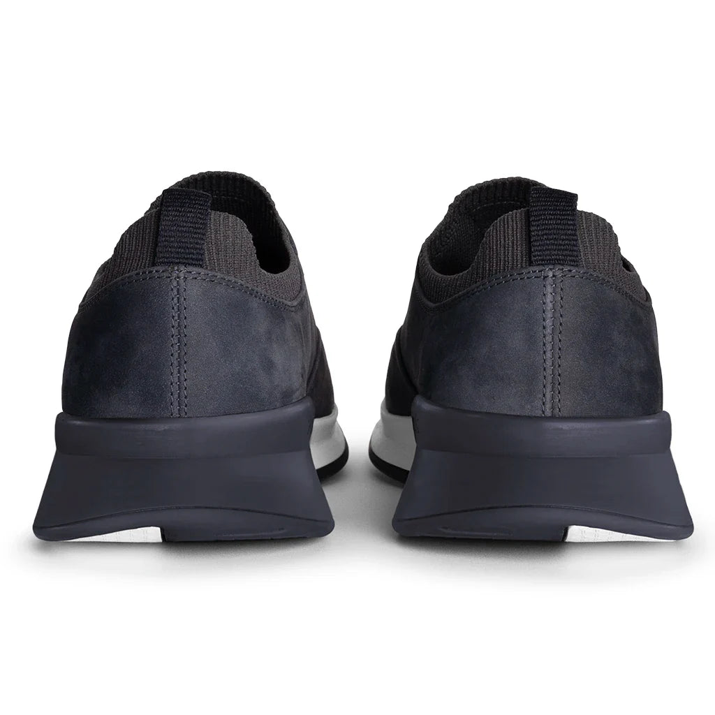 Pair of black sneakers shown from the back on a white background