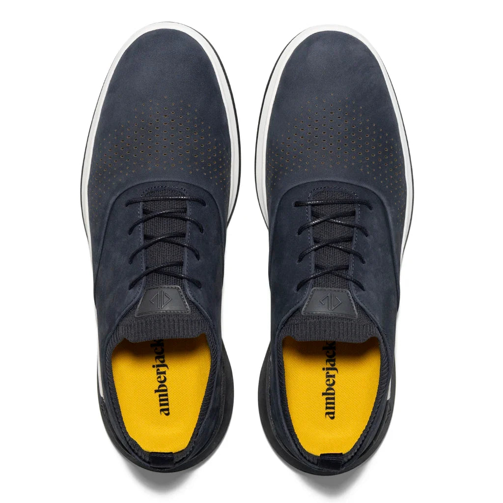 Pair of navy blue sneakers with yellow interior on a white background